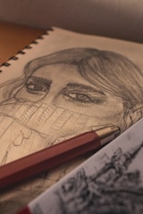 Close-up of a detailed pencil sketch showing delicate shading on a human face.