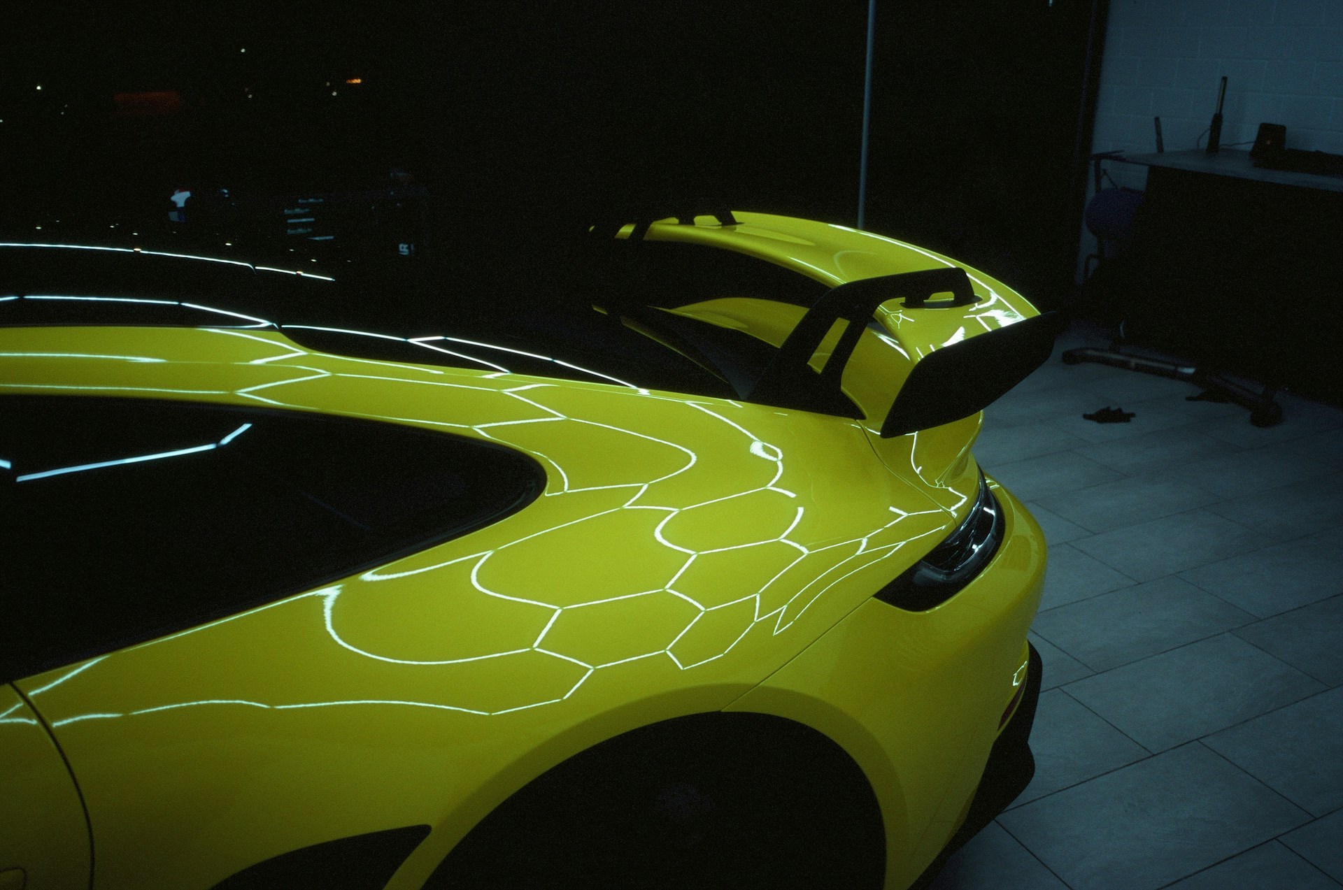 a yellow sports car parked in a garage