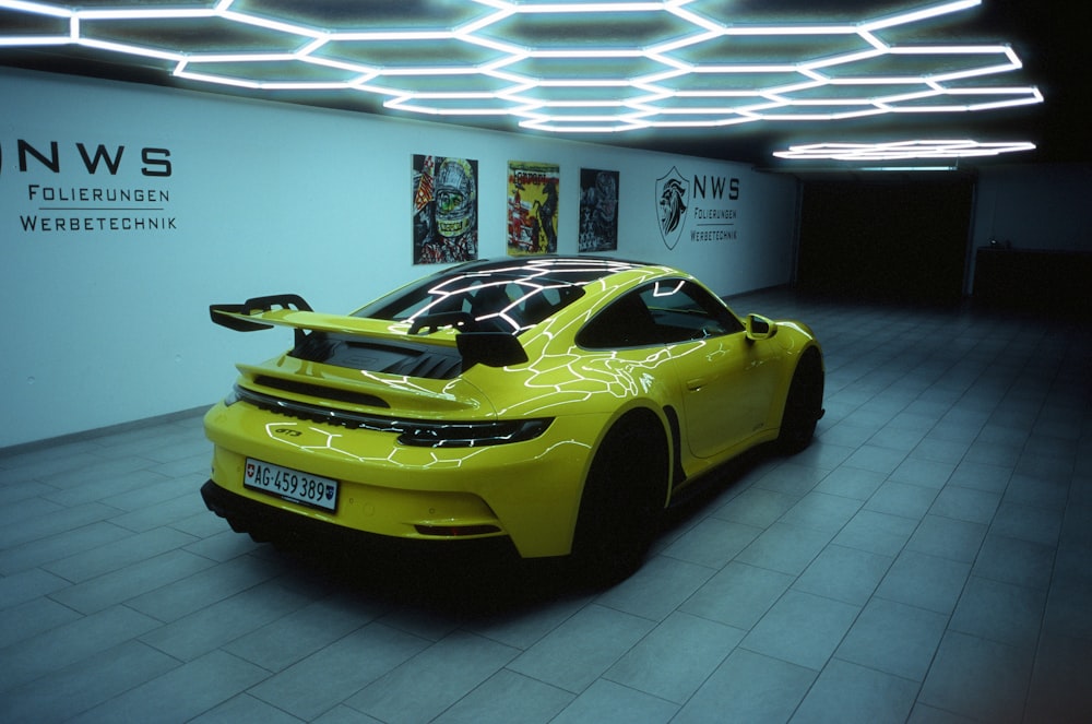a yellow sports car parked in a showroom