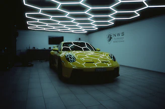 a yellow sports car in a dimly lit room