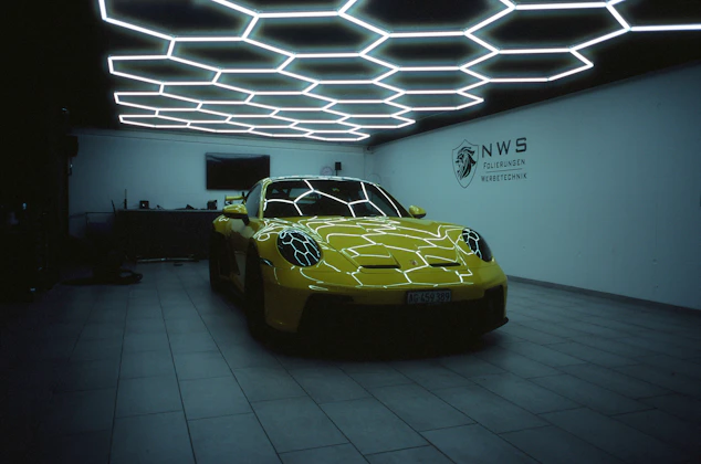 a yellow sports car in a dimly lit room