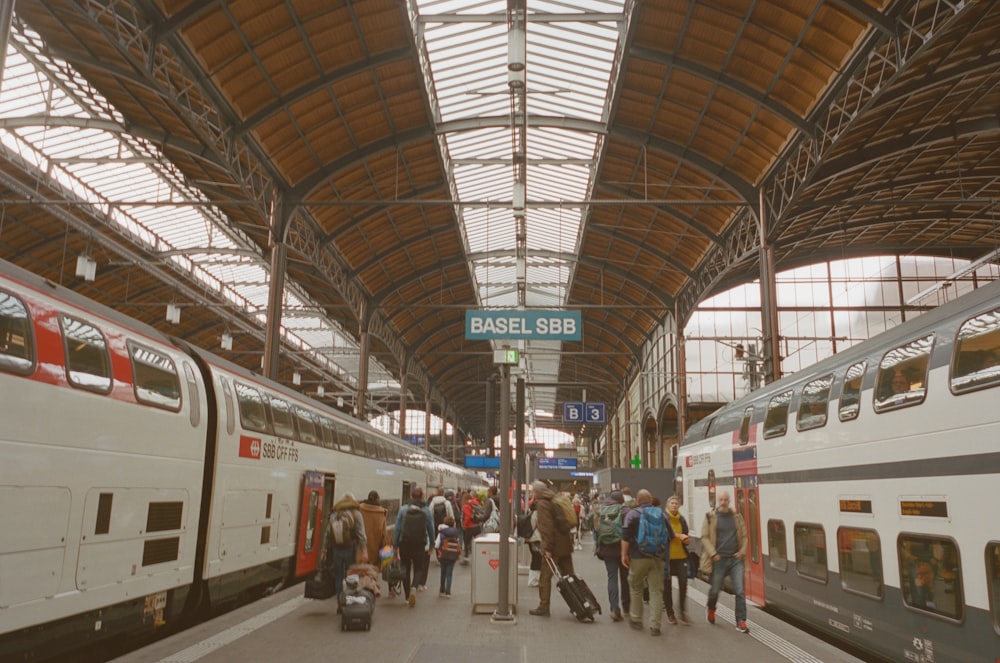 a group of people standing next to a train at a train station