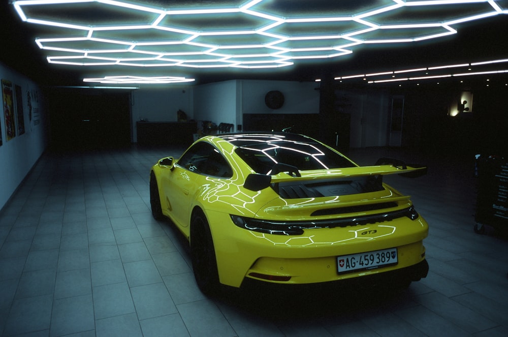 a yellow sports car parked in a garage