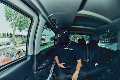 An executive passenger relaxing inside a spacious black SUV with tinted windows.