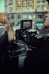 A professional journalist capturing breaking news footage in a bustling city street.