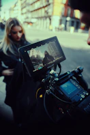 a woman standing next to a man holding a camera