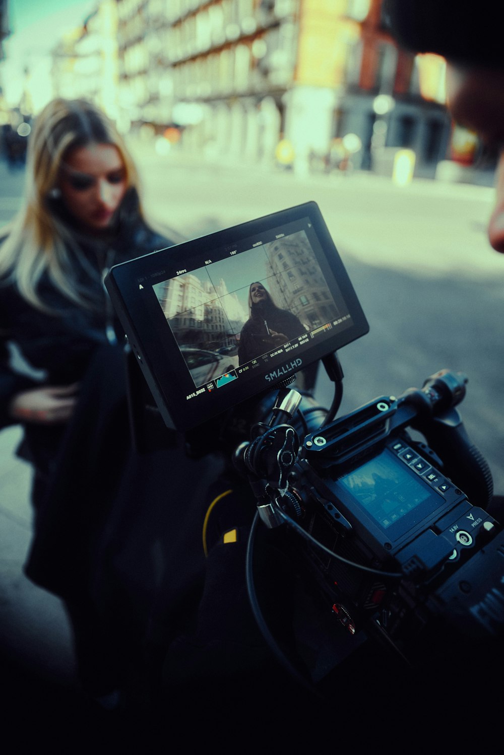 a woman standing next to a man holding a camera