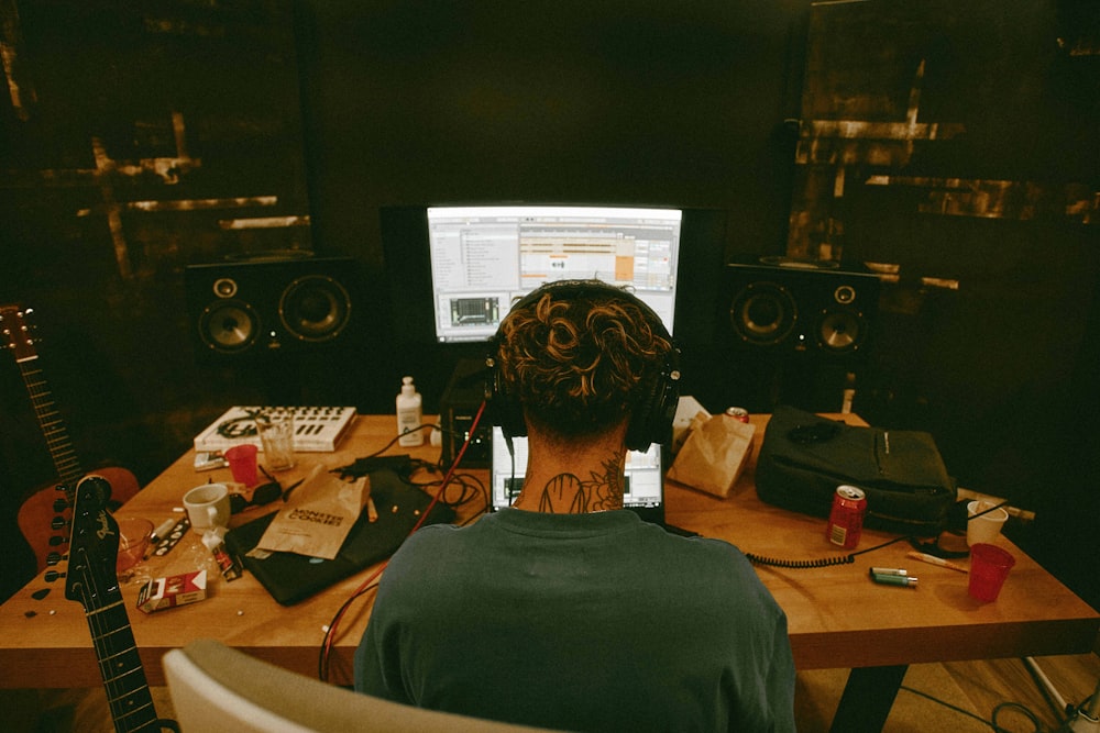 a man sitting at a desk with a guitar in front of him