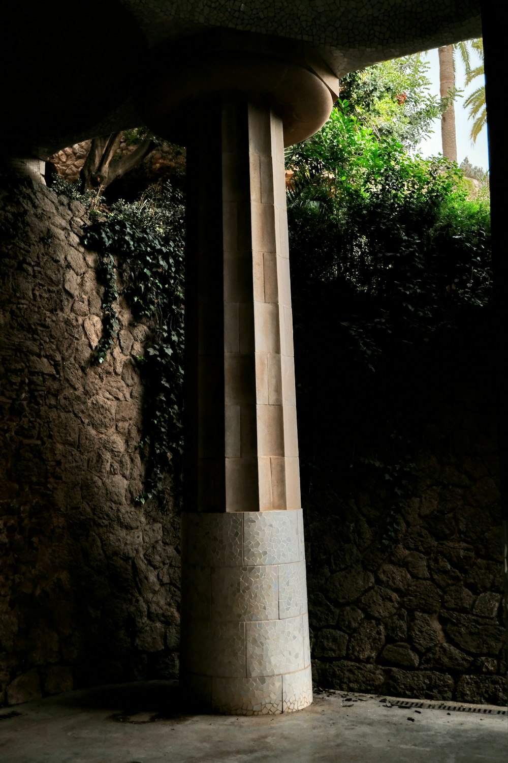 a tall pillar sitting next to a stone wall