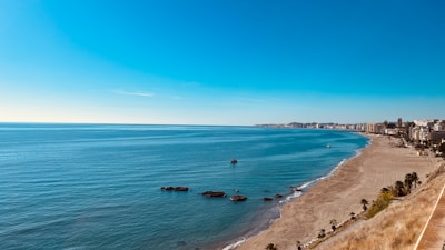 A panoramic view of a golden beach along the Kenyan coastline under clear blue skies.
