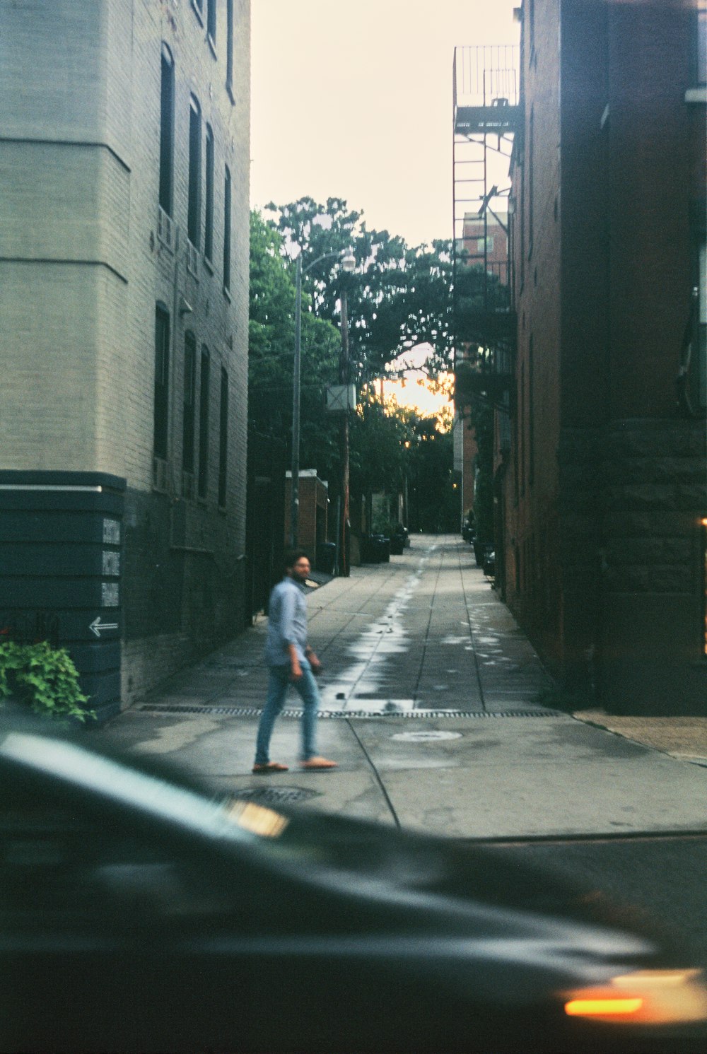 a man riding a skateboard down a street next to tall buildings