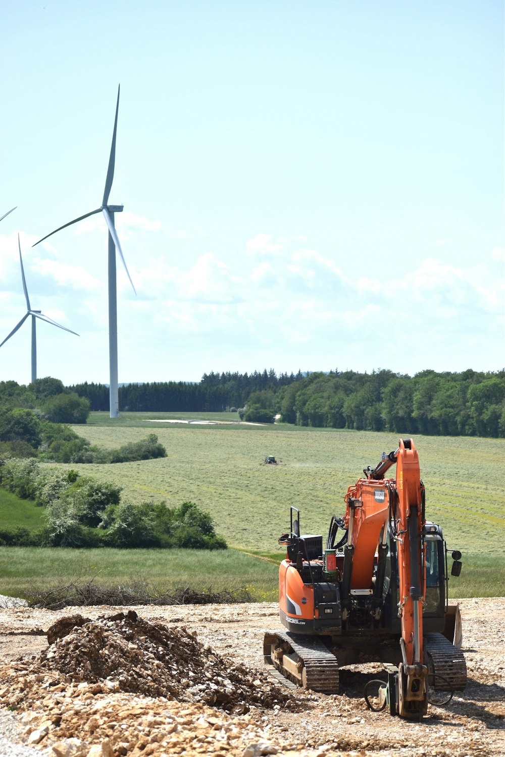 a tractor is parked in front of a wind farm