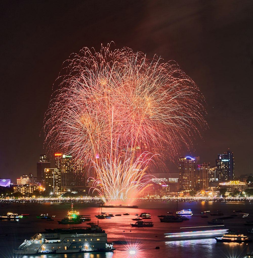 fireworks are lit up in the night sky over a city