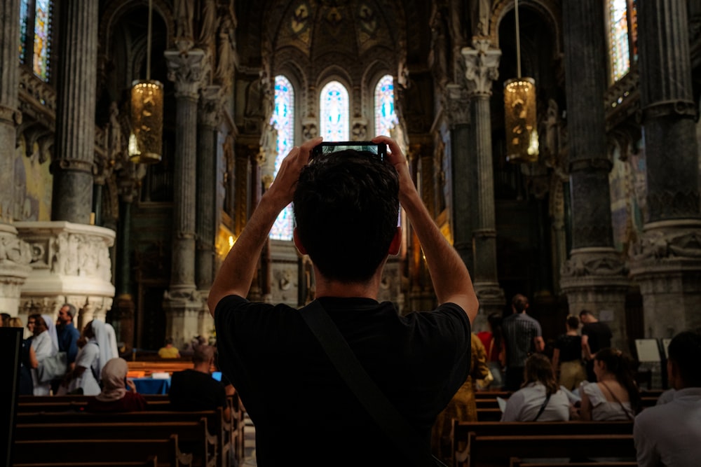 a man taking a picture of a church with his cell phone