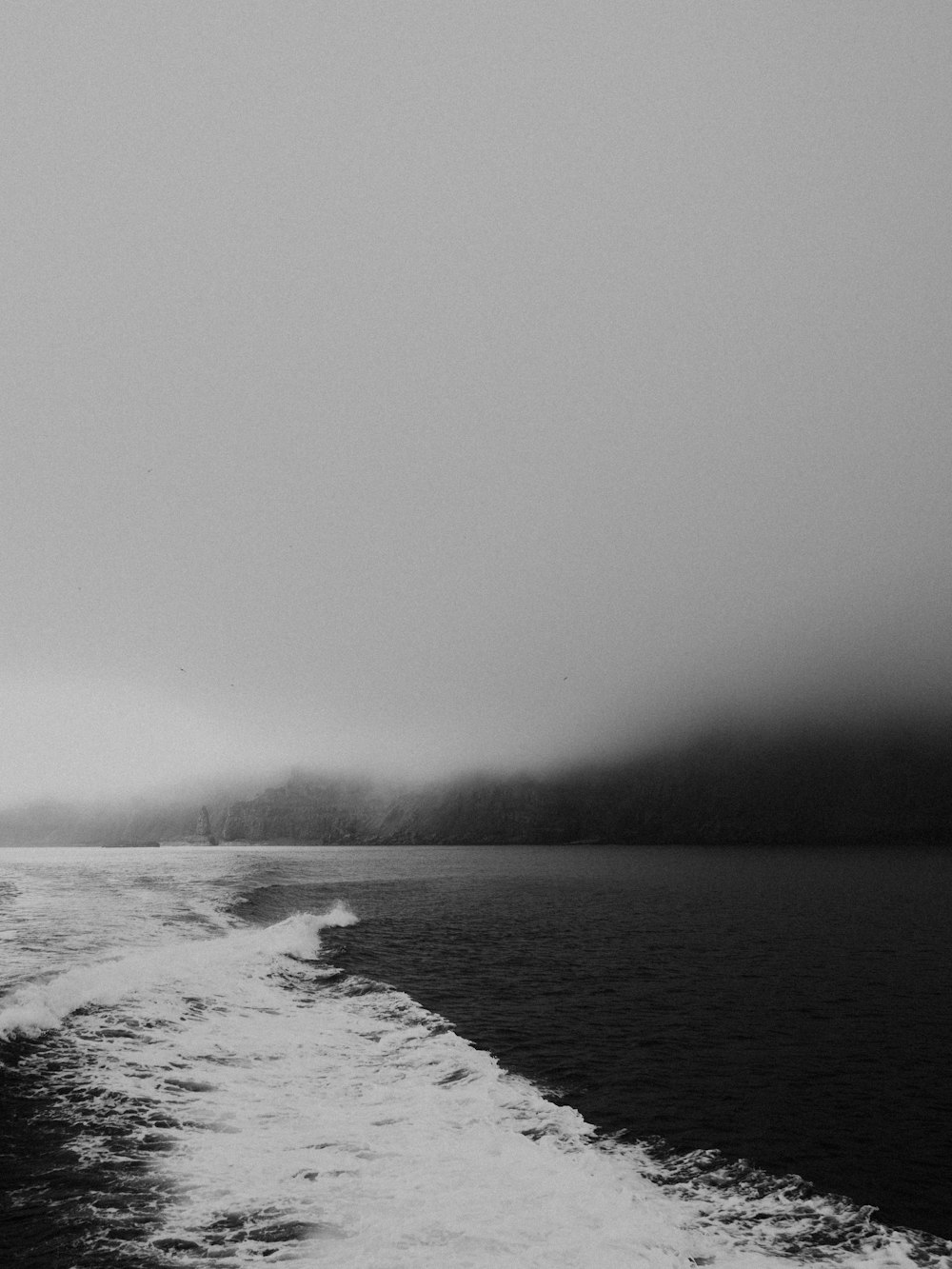 a black and white photo of a boat in the water