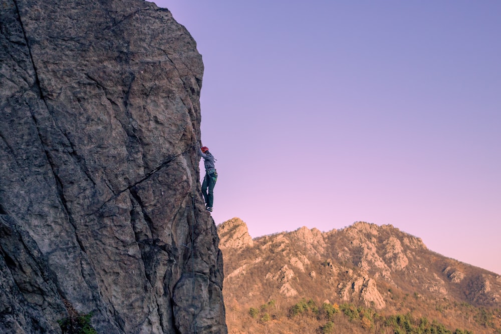 a man climbing up the side of a mountain