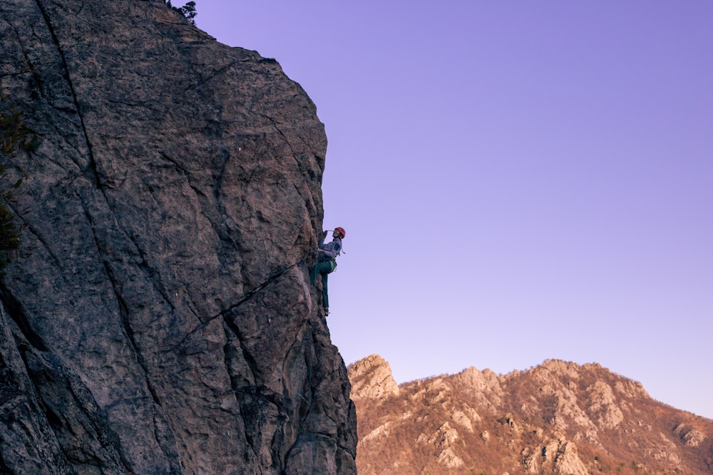 a man climbing up the side of a mountain