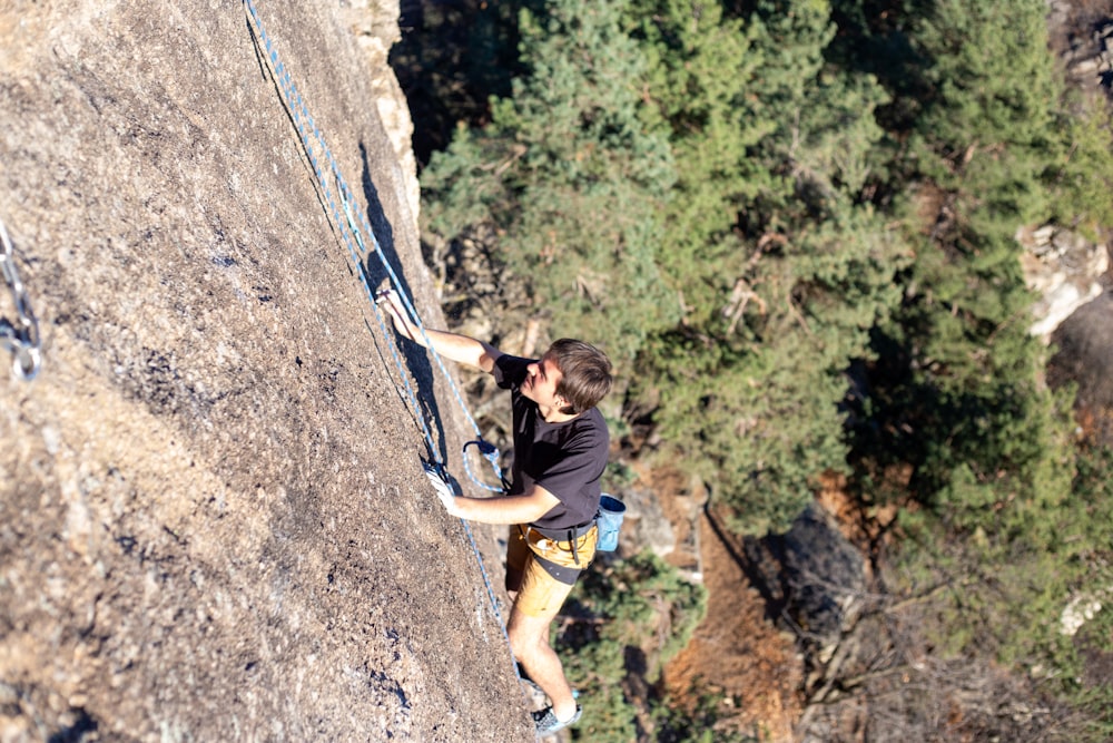 a man climbing up the side of a mountain