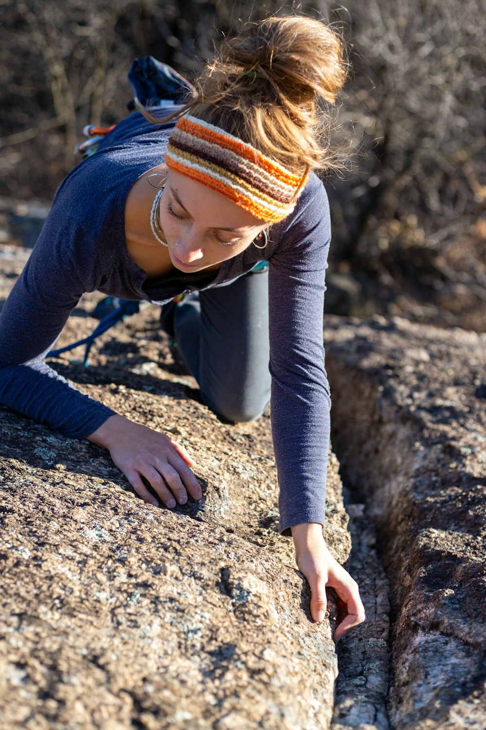 a woman climbing up the side of a mountain