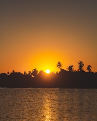 the sun is setting over a body of water