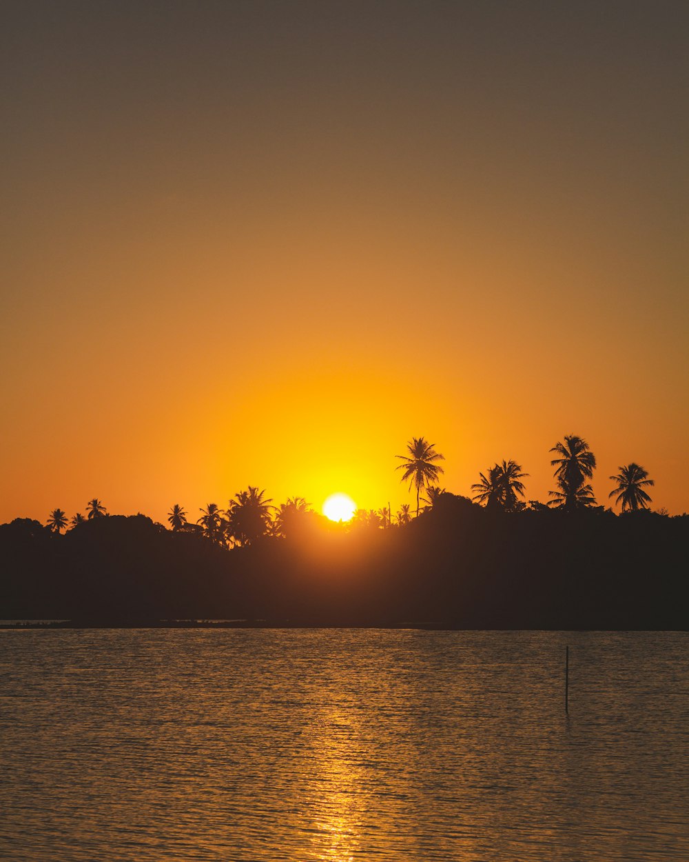 the sun is setting over a body of water