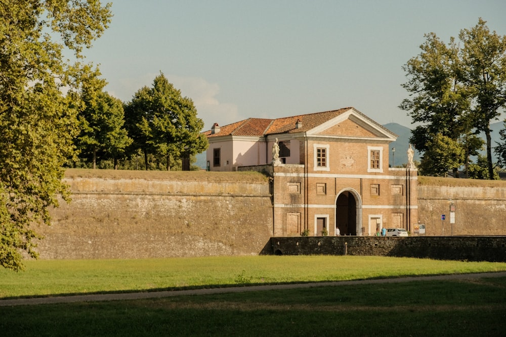 a large brick building sitting on top of a lush green field