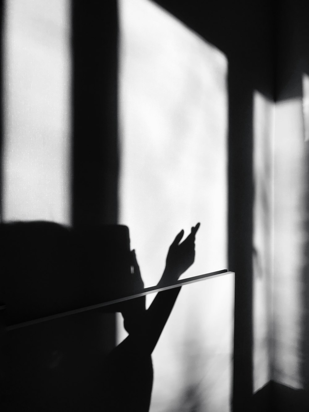 a black and white photo of a person holding a cell phone