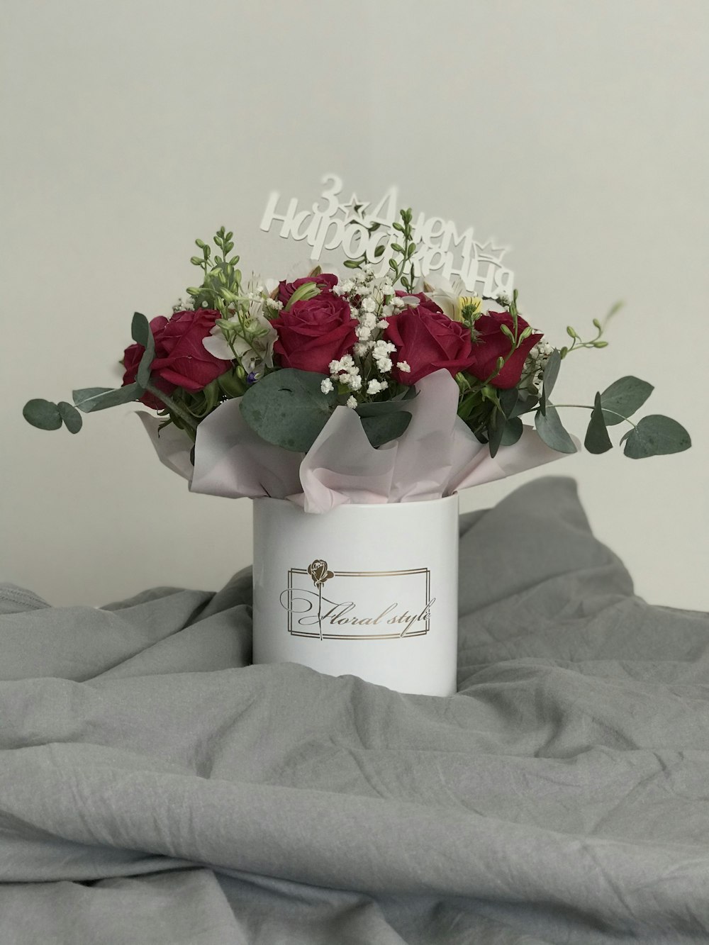a bouquet of red roses in a white vase