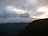 Traveler looking at a scenic mountain landscape during sunset.
