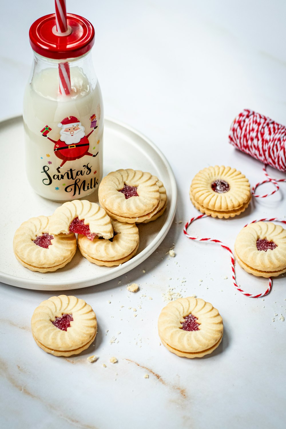 a white plate topped with cookies next to a bottle of milk