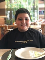 A smiling child helping to set the table, feeling proud and involved.