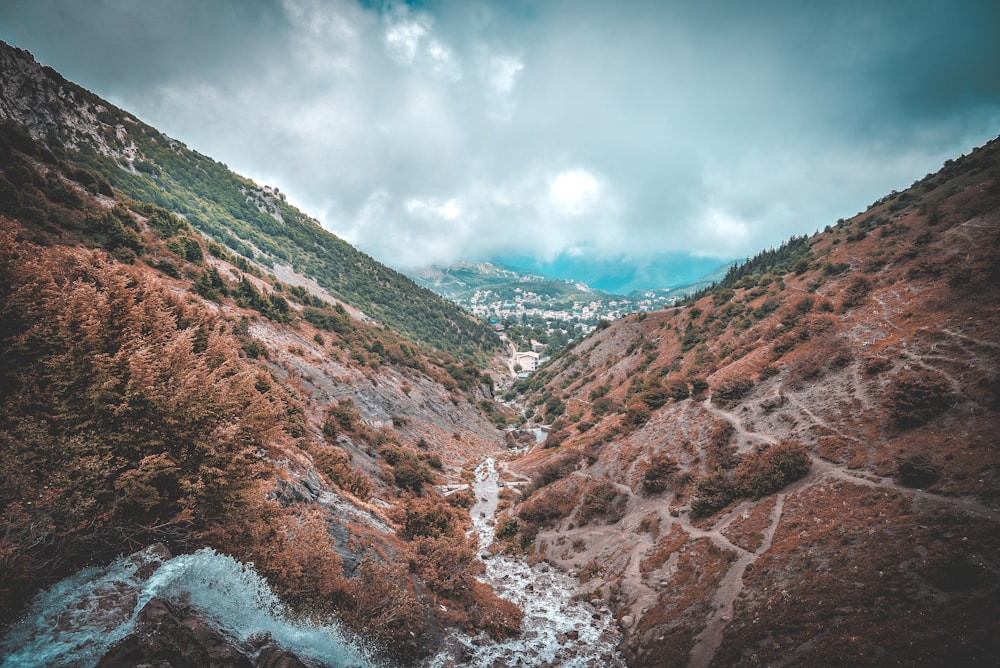 a river running through a valley surrounded by mountains