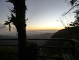 Balcony view from a room showing the serene mountain landscape at sunset.