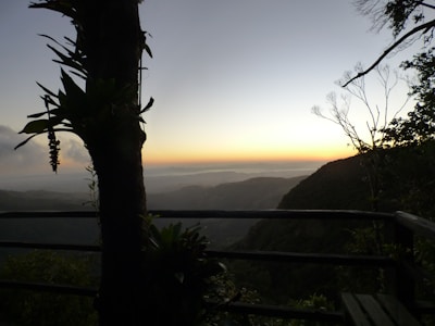 Balcony view from a room showing the serene mountain landscape at sunset.