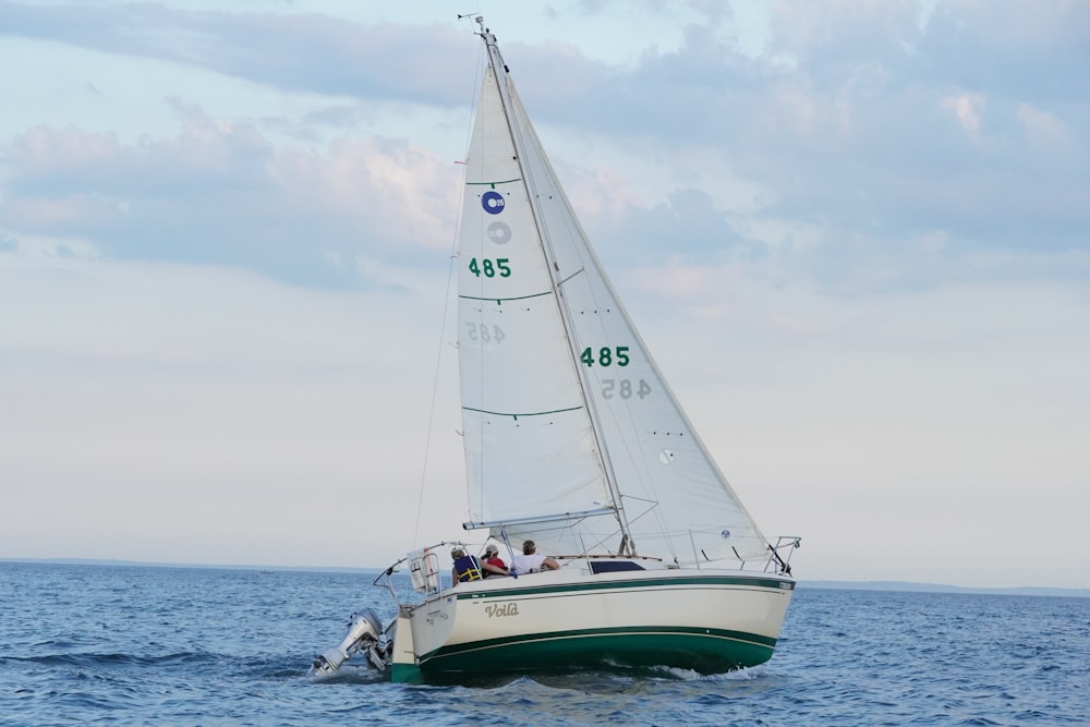 ein Segelboot mit Menschen darauf, die auf dem Ozean segeln