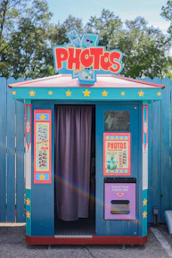 A modern photo booth with guests laughing and taking instant printed photos.