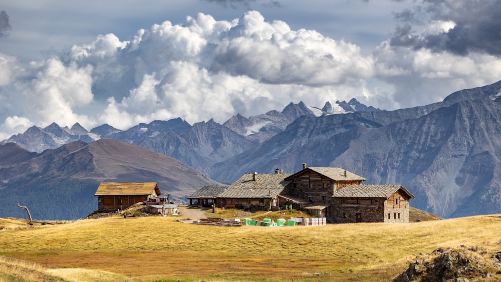 a house in a field with mountains in the background