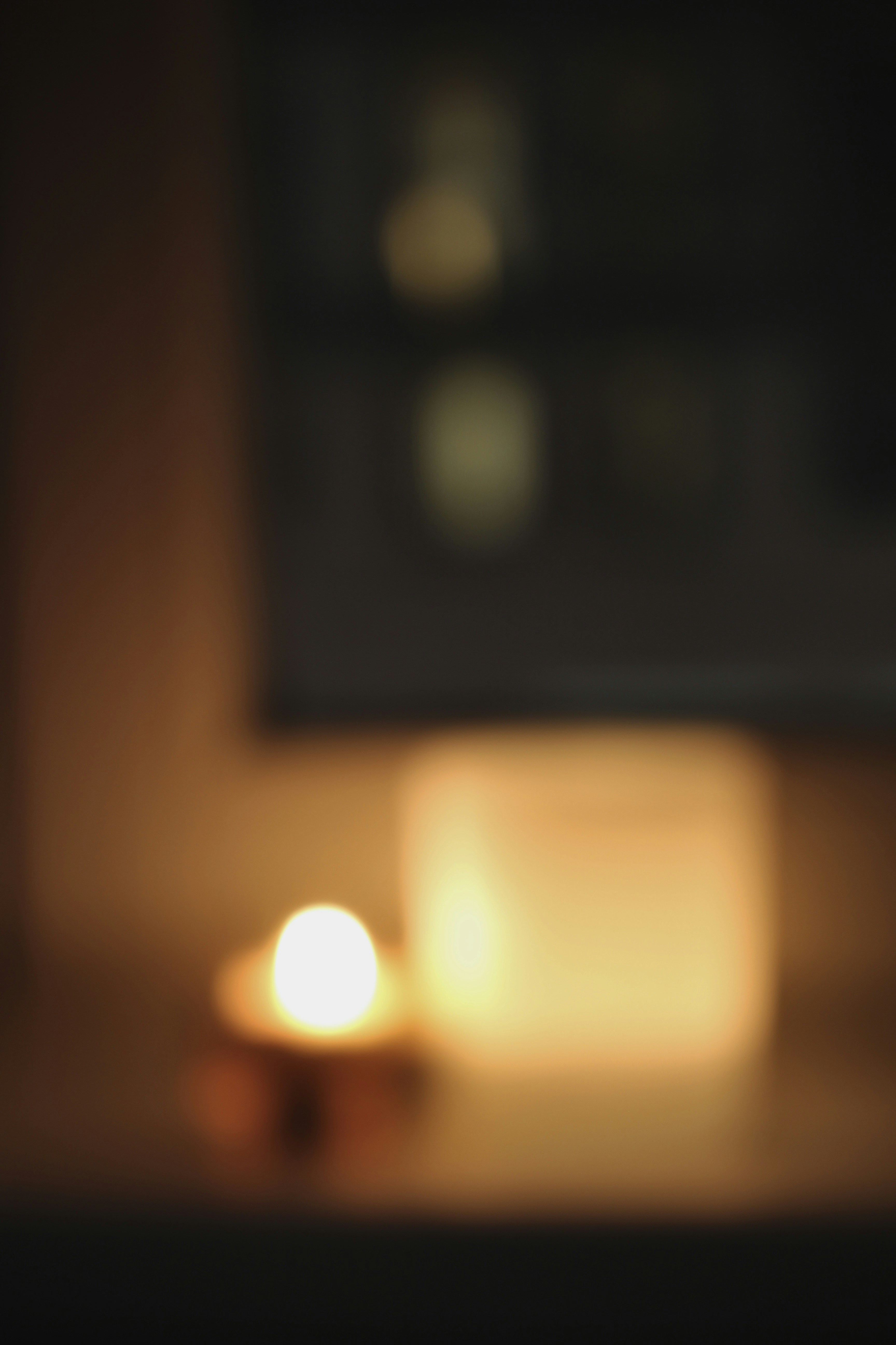 Warm atmospheric portrait setting, soft golden candlelight, dark background with deep shadows, intimate and moody ambiance