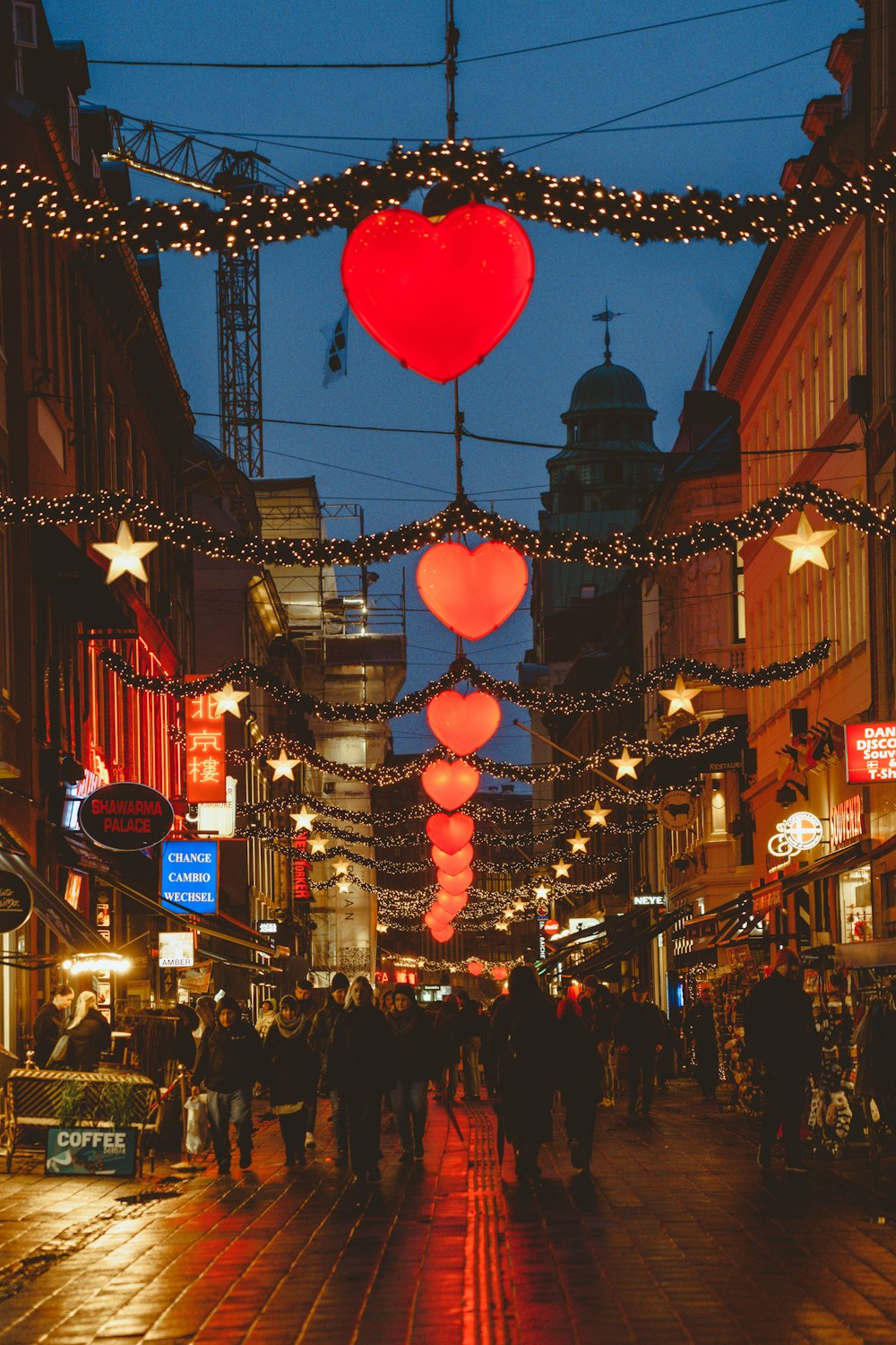 people walking down a city street at night