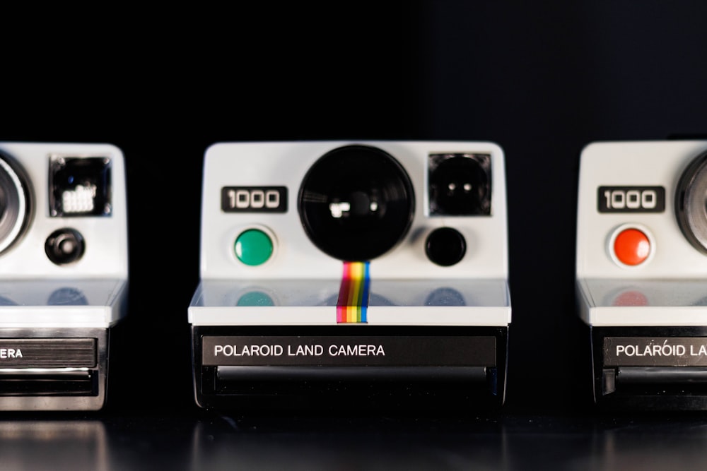 a couple of polaroid cameras sitting on top of a table
