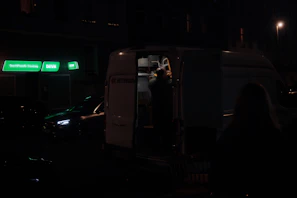 Team members coordinating efficiently while securing furniture inside the moving van with blue electric lighting accents.