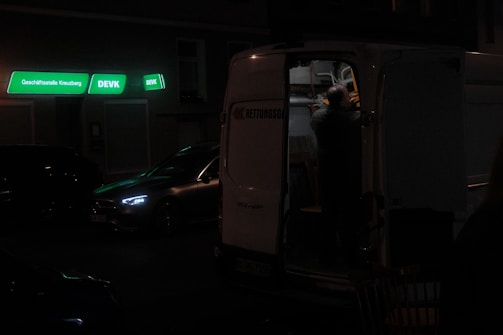 A friendly driver loading boxes into the back of a slightly battered van.