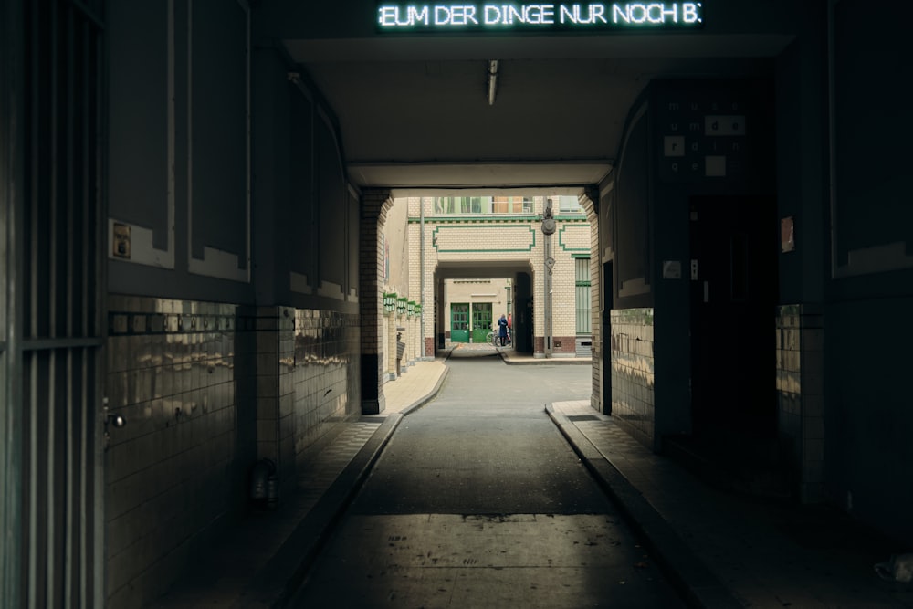 a long hallway with a neon sign above it