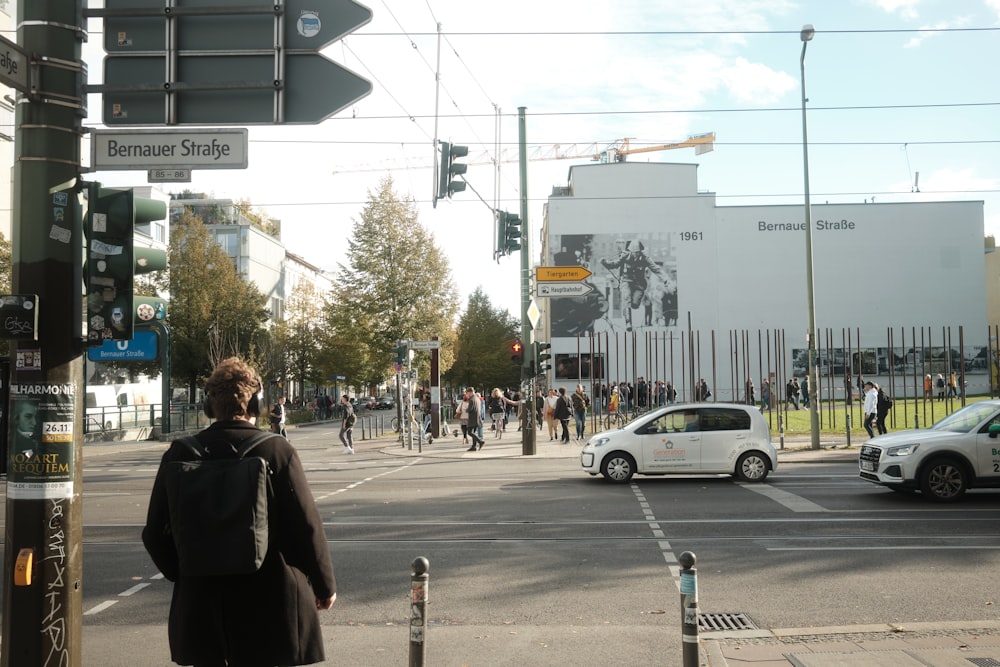 a man standing on the side of a road next to a traffic light