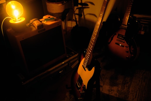 A cozy home studio with vintage guitars and warm lighting, where Charlie and David Peters create their music.