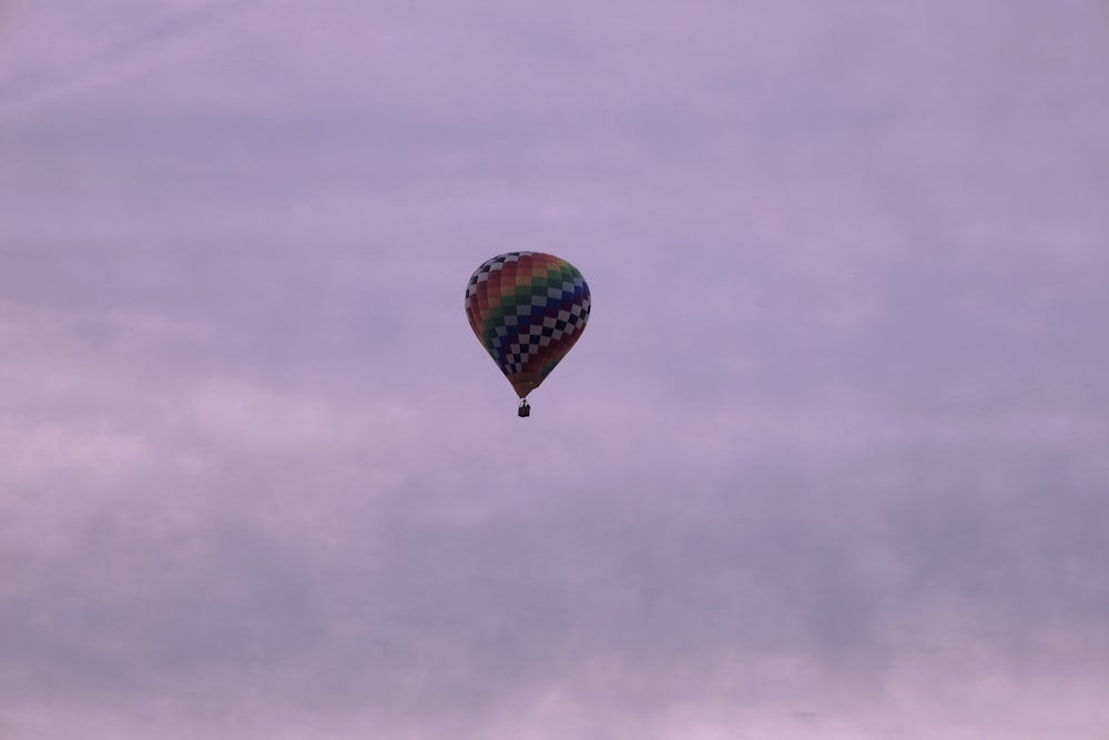 a colorful hot air balloon flying through a cloudy sky