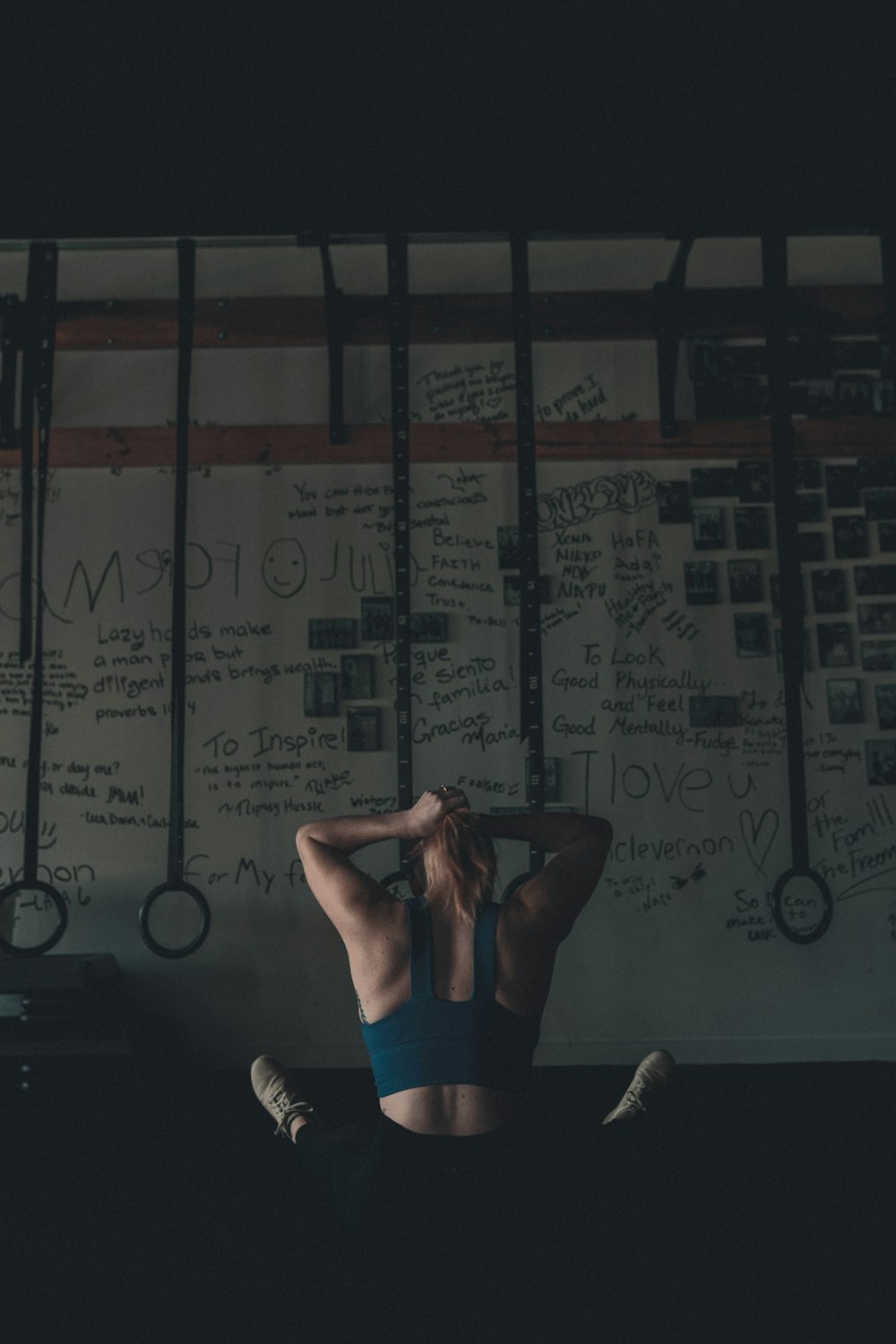 a woman sitting on a bed in front of a wall with writing on it