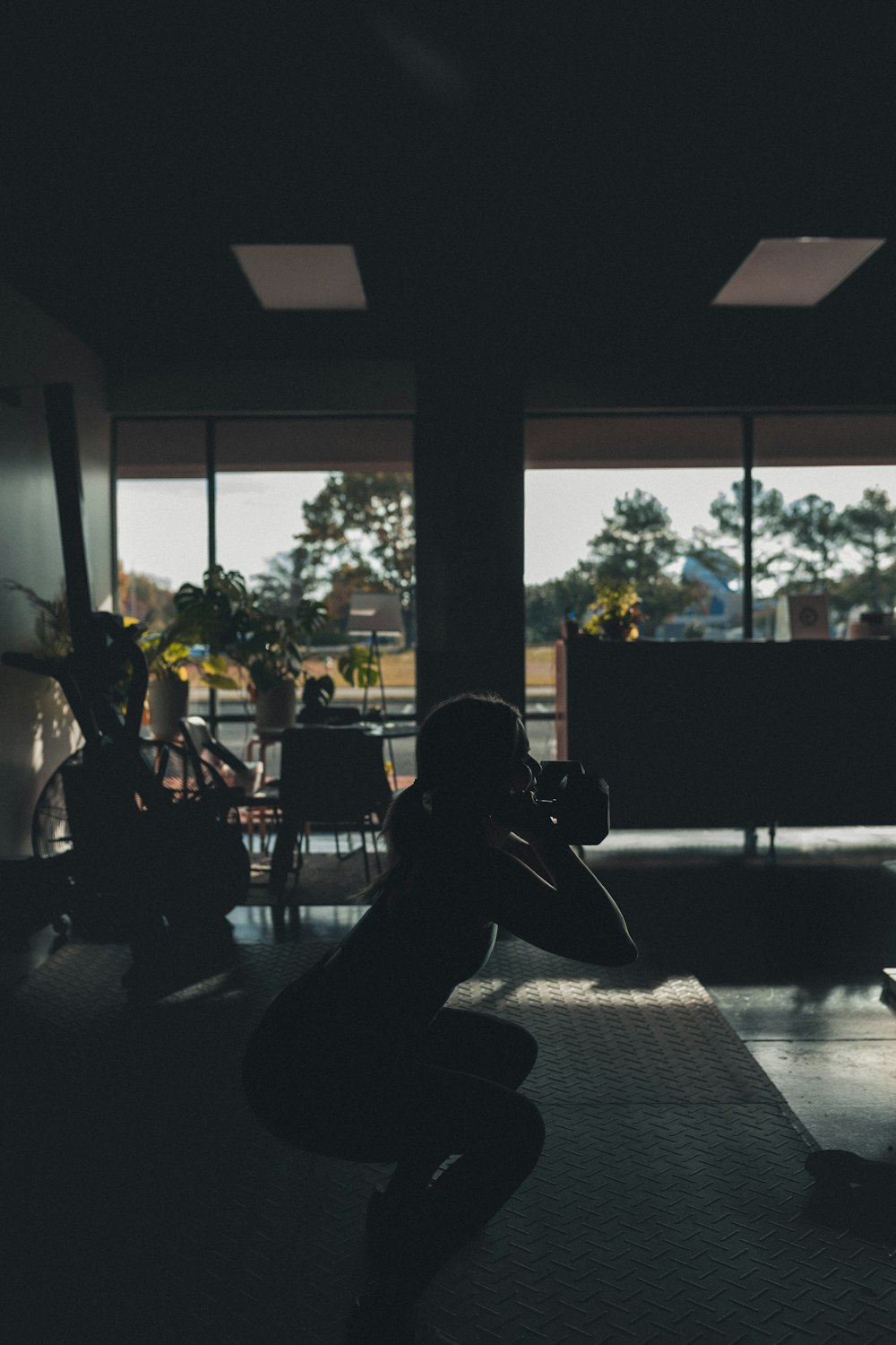 a woman squatting on a yoga mat in a dark room