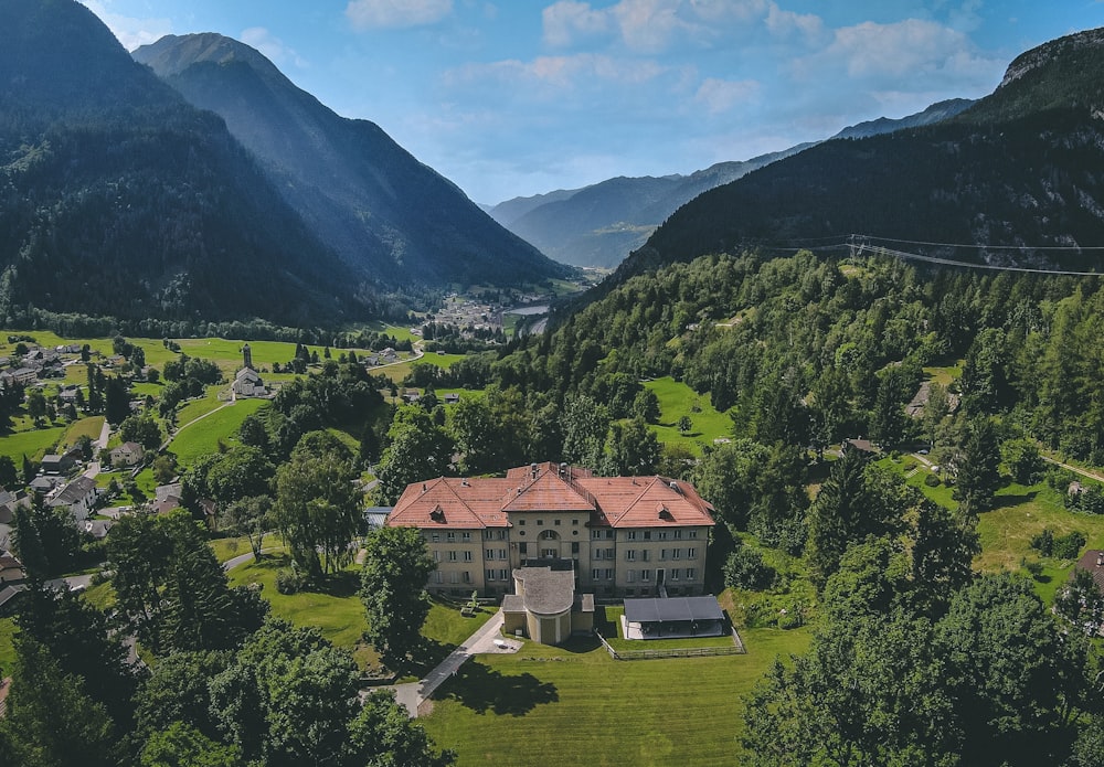 an aerial view of a large house surrounded by mountains