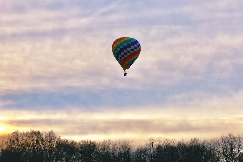 a colorful hot air balloon flying through a cloudy sky